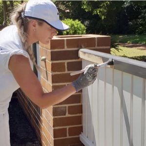 Katrina Anderson from Unique Design Painting and Decorating painting a fence