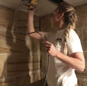 Katrina Anderson from Unique Design Painting and Decorating sanding a ceiling